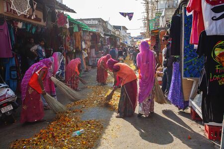 Pushkar in Rajasthan, India, February 13, 2018: Indian women cleaning Pushkar street from festive...