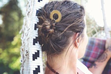 Elegant woman in a swing wearing metal hair pin in her hair bun