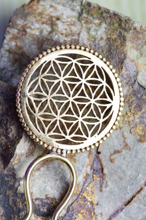 Brass metal yellow golden hair pin detail on natural rocky backgroundの写真素材