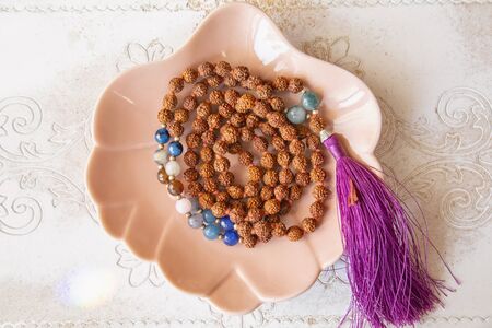 Indian rudraksha seed beads 108 mala necklace with Buddha pendant tassel on decorative backhroundの写真素材