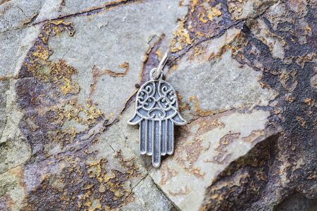 sterling silver metal pendant on natural background in the shape of hamsa, fatima handの写真素材