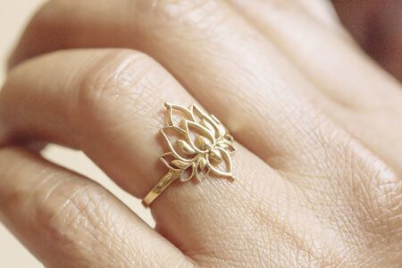 Hand wearing elegant golden ring in the shape of the lotusの写真素材