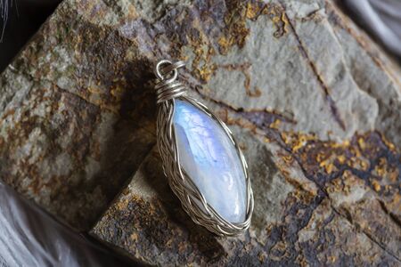 Beautiful moon stone pendant on rocky backgroundの写真素材