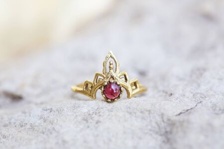 Golden metal silver ornamental ring with garnet mineral stone