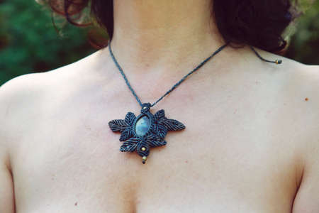 Female neckline wearing mineral gemstone necklace in macrame techniqueの写真素材