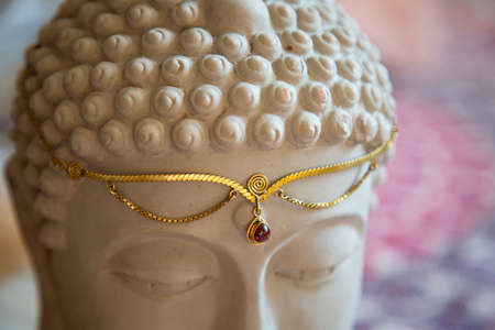 Brass tiara with gemstone on Buddha statue headの写真素材