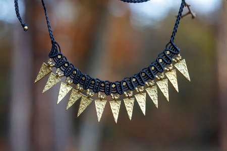 Boho style necklace with metal components in the forest backgroundの写真素材