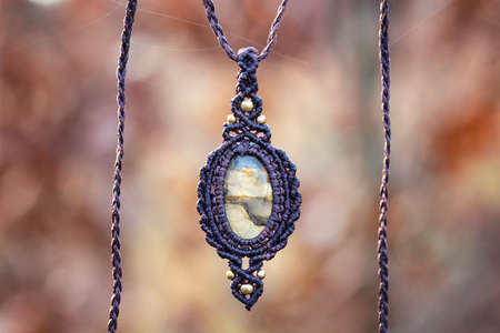 Mineral gemstone ornamental pendant on blury forest backgroundの写真素材