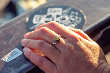 city outdoor closeup of female hand wearing silver ring with beautiful labradorite gemstone