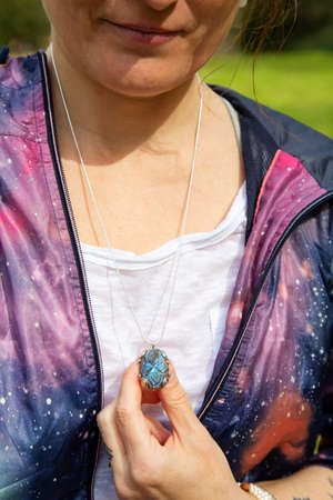 Girl chest detail in space jacket with labradorite pendant on silver chain