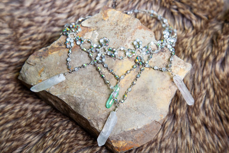Crystal quartz romantic princess necklace from fairytale on rocky stone backgroundの写真素材