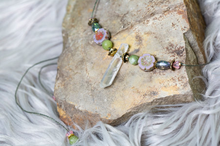 Crystal quartz romantic princess necklace from fairytale on rocky stone backgroundの写真素材