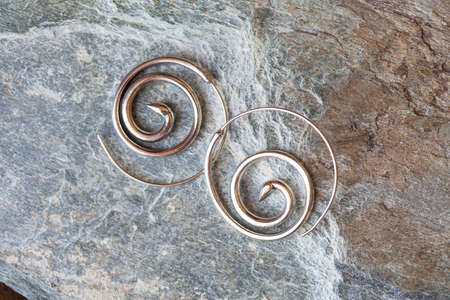 Silver metal decorative oriental spirale design earrings on natural neutral backgroundの写真素材