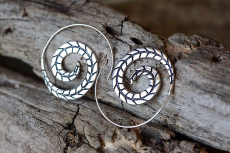 Silver metal decorative oriental spirale design earrings on natural neutral backgroundの写真素材