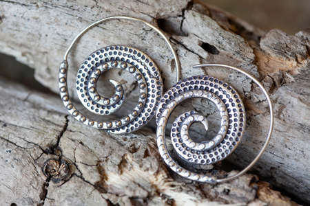 Silver metal decorative oriental spirale design earrings on natural neutral backgroundの写真素材