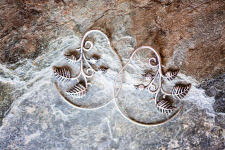 Silver metal decorative oriental spirale design earrings on natural neutral backgroundの写真素材