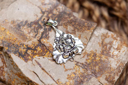 Brass metal pendant on natural background in the shape of dragonの写真素材