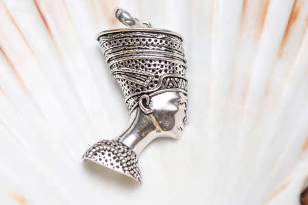 Brass metal pendant on natural background in the shape of dragonの写真素材