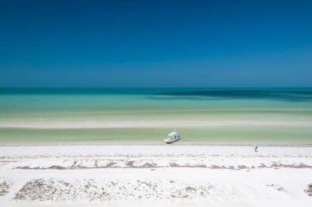Panoramic aerial view Caribbean Sea in Holbox island Mexico. Tourists swimming in the turquoise sea. A boat rests quietly on the white sand of the beachの写真素材