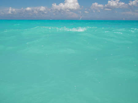View over the surface of the water of the tropical sea, in the background sailing boats, the blue sky and white clouds. Playa del Carmen, Mexicoのeditorial素材
