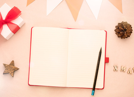 Top view of Christmas background with blank open notepad, decorations and gift boxの写真素材