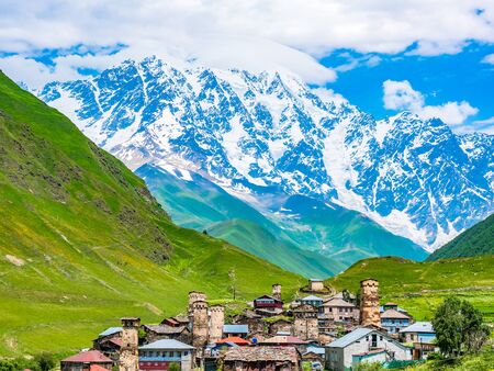 Wonderful view on village in the mountains against blue sky in Svaneti region, Georgia. Traditional ancient Svan Towers on a green hill in a sunny dayの写真素材