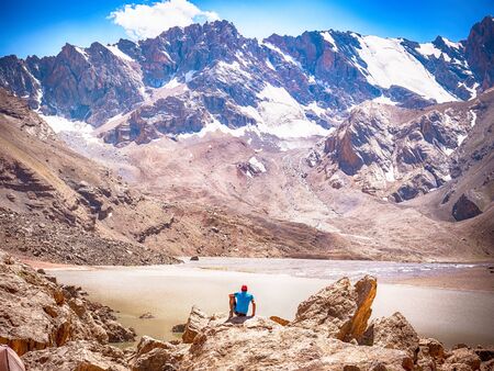 Hiker near Lake Moutniy on rocky mountain background. Fann Mountains, Tajikistan, Central Asia