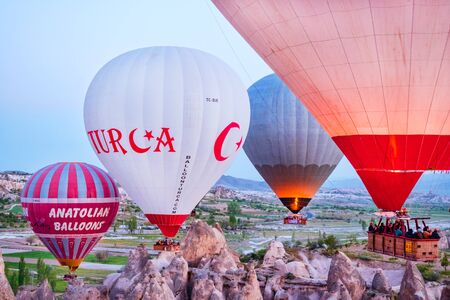 GOREME, CAPPADOCIA, TURKEY - APRIL 19, 2018: Colorful hot air balloon flying over rock landscape at Cappadocia, Turkeyのeditorial素材
