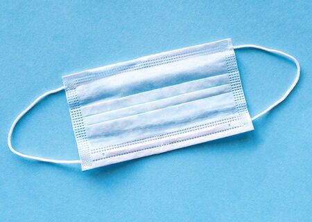 Medical shielding bandage on blue background. Surgical mask to cover the mouth and nose. Protection...
