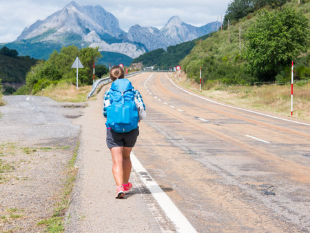 Lonely Pilgrim with backpack walking the Camino de Santiago, ruta Vadiniense. Cantabrian, Riano, province of Leon. Castile and Leon, northern Spain. Way of St Jamesの写真素材
