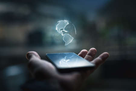Earth hologram above smartphone screenの写真素材