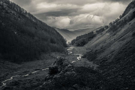 Mysterious black mountain with dramatic cloudy skyの写真素材