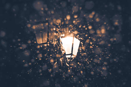 Night snowfall in the light of street light photographed with an old lensの写真素材
