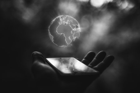 Earth hologram above smartphone screenの写真素材