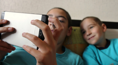 Children look at the screen of the tablet.