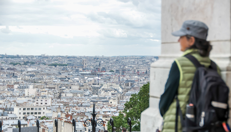 Woman looking at Paris from the Basilica of  Sacré-Coeur on Montmartre, hill in the noth of Paris.の写真素材