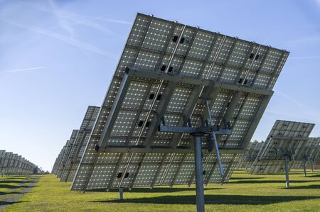 Solar system, overview Solar power plant with trackable elements in sunshine Rear view with module...