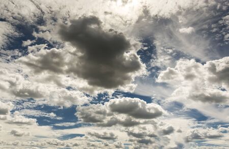 Dramatic cloud sky with dark rain clouds and sun before and after thunderstormの写真素材