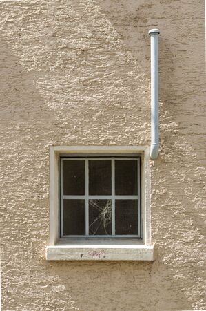 Facade of an old building with metal windows and wired glass vertical exhaust pipeの写真素材