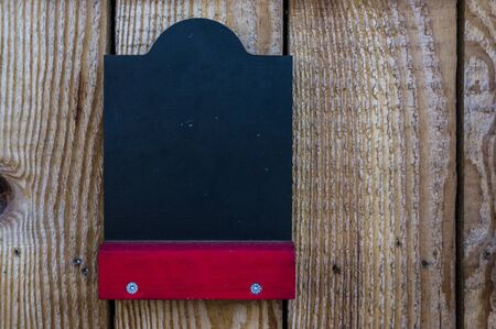 empty chalk board on a wooden sales stand with red shelf for free labelingの写真素材