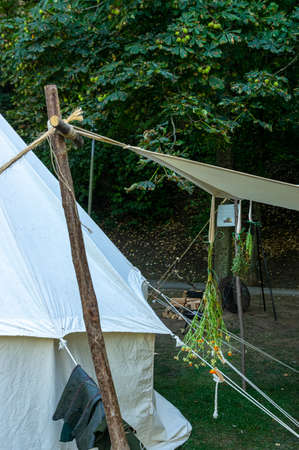 Reenactment of a medieval scene against the historical backdrop of an old city wall, village with tents of various designs with details of fabrics and pegs, ropes and bracing, view of tentsのeditorial素材