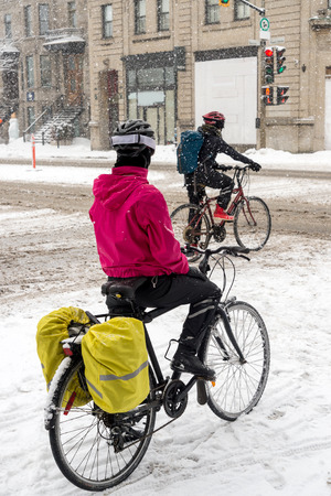 Montreal, CA, 7th March 2016. Two people riding bikes during snow stormの写真素材