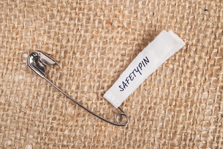 Safety pin on clothes with label "Safetypin" as a symbol of solidarityの写真素材