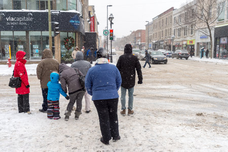Montreal, CA - 17 December 2016: Snowstorm in Montreal. Pedestrians on Mont-Royal Avenue.のeditorial素材