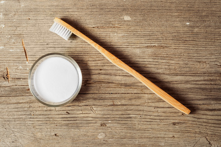 Baking soda next to a tooth brush on a wooden boardの写真素材