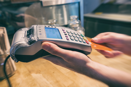 Close up of a hand using a credit card terminal to payの写真素材