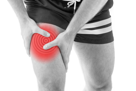 Man with quadriceps pain over white backgroundの写真素材