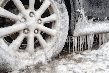 Ice buildup and icicles on a car and close-up of a frozen wheel, in Montreal, Canada.の写真素材