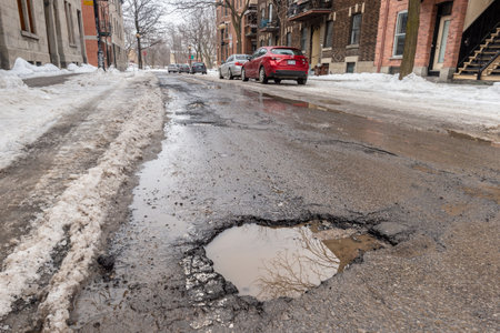 Montreal, CA - 13 March 2019: Large pothole in Montreal street, in Winterのeditorial素材
