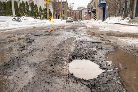 Montreal, CA - 13 March 2019: Large pothole in Montreal street, in Winterのeditorial素材